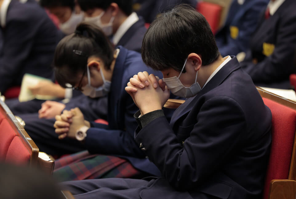 祈りをささげる様子の生徒たち